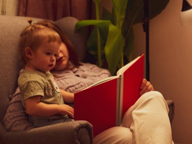 Anne ve kızı sandalye yaşam tarzında bir kitap okudular.