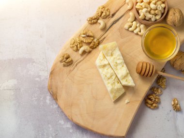 Tahtadaki sert peynir dilimleri fındıklı ve ballı en iyi kombinasyon.