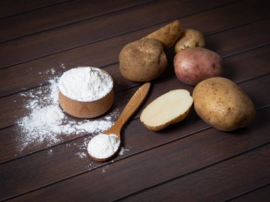 Patatesli nişasta ve siyah ahşap arka plan..