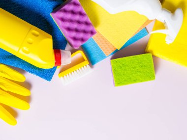 Renkli ev temizleme aletleri jelleri. Süngerler Mor arkaplan kopyalama alanı üzerindeki paçavralar