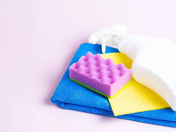 Beyaz şişe, paçavra, mor arka planda sünger mutfak, banyo ve diğer yerlerin çeşitli yüzeylerini temizlemek için bir set. Boşluğu kopyala