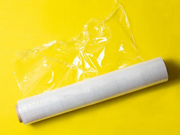 黄色の背景に包装用の包装用ストレッチフィルムのロールを分離 — ストック写真