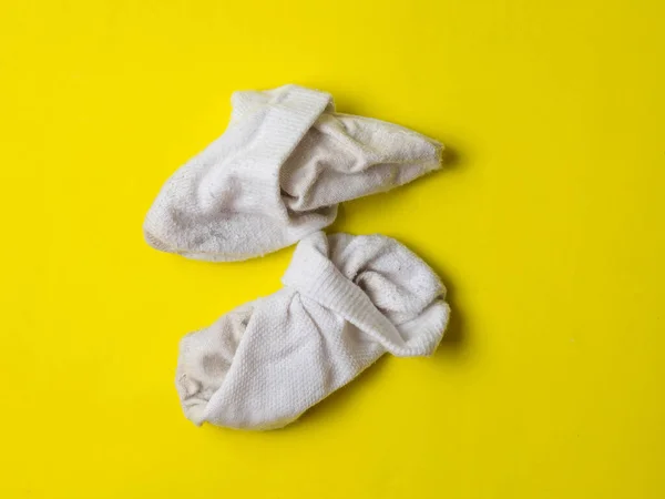 黄色の背景に白い汚れた靴下を砕き — ストック写真