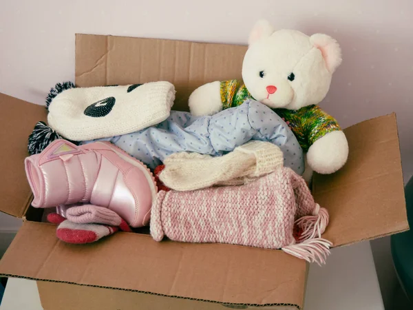 donations to the needy, warm baby clothes and toys in a cardboard box, donations for children