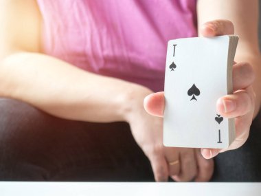 a deck of playing cards in a girl's hand with an ace of spades