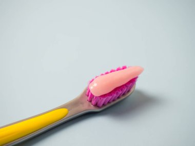 Pembe diş macunlu diş fırçası. Diş fırçasındaki pembe diş macununu kapat..