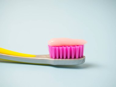 Pembe diş macunlu diş fırçası. Diş fırçasındaki pembe diş macununu kapat..