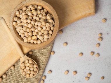 Tahta kase ve açık beton zeminde nohut dolu ahşap kaşık. yakın plan