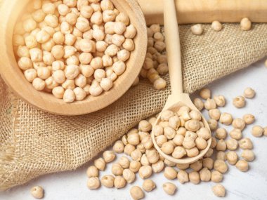 Tahta kase ve açık beton zeminde nohut dolu ahşap kaşık. yakın plan