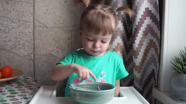 Ein Kleines Mädchen Grünem Kleid Sitzt Einem Hochstuhl Und Isst — Stockvideo
