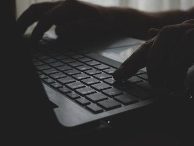 Erkek ellerinin dizüstü bilgisayarda yazı yazarken ve internet üzerinde uzaktan çalışma konseptinde sörf yaparken görüntüsünü kapat