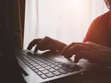 Erkek ellerinin dizüstü bilgisayarda yazı yazarken ve internet üzerinde uzaktan çalışma konseptinde sörf yaparken görüntüsünü kapat