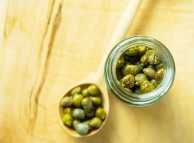 Cam kavanozda kapari. Tahta bir manzarada kavanozda turşulu kapari.