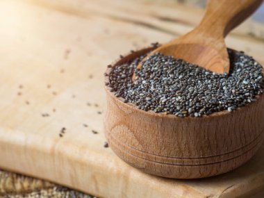 Masanın üzerindeki tahta kaşıkta sağlıklı Chia tohumları.