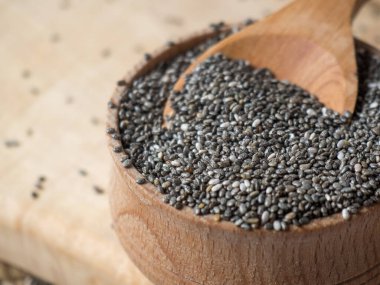 Masanın üzerindeki tahta kaşıkta sağlıklı Chia tohumları.