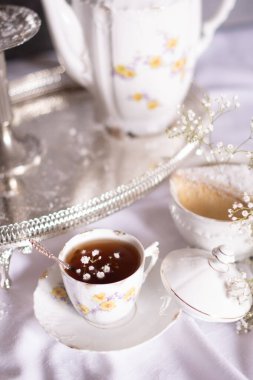 Peynirli kek ve çingeneyle beyaz sakin bir hayat ve bir fincan çay, hafif ve havadar