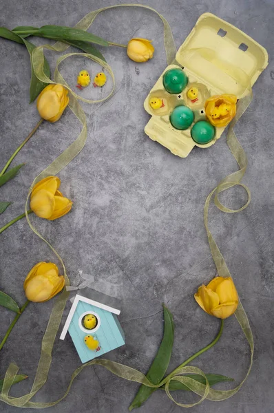 Великоднє компонування, тарілка з курки та жовтих пташенят, зеленими яйцями, тюльпанами — стокове фото