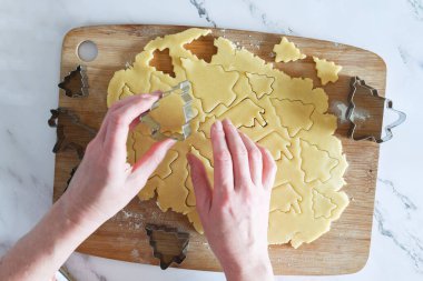 Noel kurabiyeleri için kısaekmek hamurundan figürleri kesme süreci