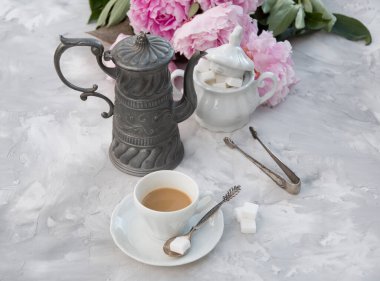 Bir fincan kahveyle bir buket pembe şakayığa karşı klasik hayat. 