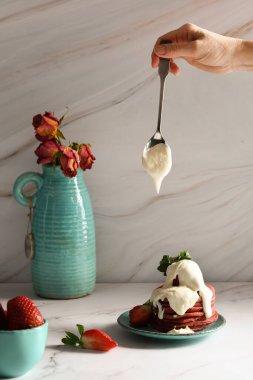 Turkuaz bir tabakta ekşi kremalı pembe çilekli gözlemelerle hayat