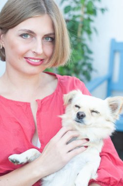 Portre güzel genç sarışın gülümseyen ve evcil köpek Chihuahua