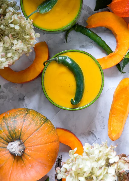 Pumpkin puree soup in green bowls on gray cement background, colorful food, — Stock Photo, Image