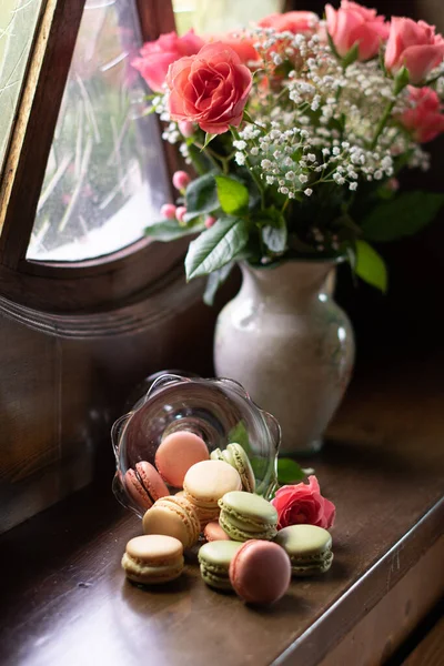 Still life on the windowsill, flowers and macaroons, pink roses, colorful candys — Stock Photo, Image