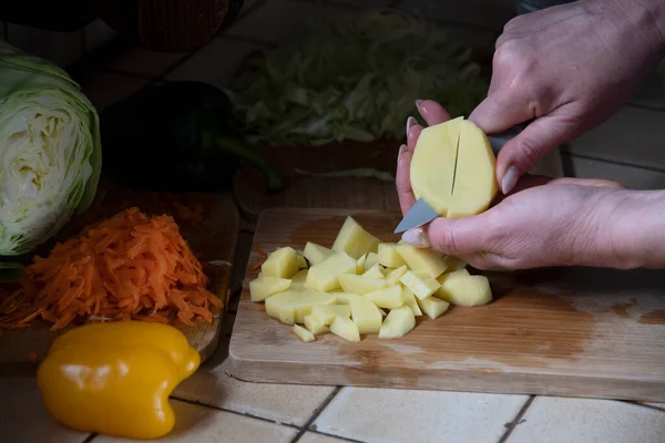 Uma Mulher Corta Batatas Cozinha Contra Fundo Vegetais Frescos Ingredientes — Fotografia de Stock
