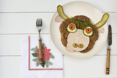 Siyah ekmek, sosis ve sebzeden yapılmış neşeli bir boğanın sandviçi. 