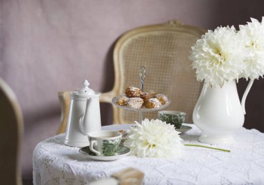 tea break in english style, vintage retro still life, homemade buns and a bouquet of white dalias. High quality photo