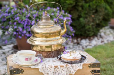copper vintage teapot and banana cream cake at picnic outdoor,vintage background,High quality photo