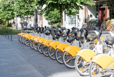 public yellow bicycles parked in the sharing on the street BRUSSELS, BELGIUM High quality photo