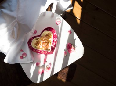 Kalp şeklinde elmalı turta, beyaz bir sandalyede, güneş gölgesinin altında duruyor ve Sevgililer Günü için ev yapımı pastalar, Anneler Günü için. Yüksek kalite fotoğraf