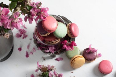 rengarenk badem kurabiyeleri ve pembe elma ağacı çiçekleriyle dolu bir vazo, renkli tatlı yiyecekler. Yüksek kalite fotoğraf