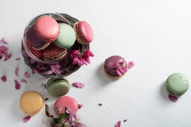 rengarenk badem kurabiyeleri ve pembe elma ağacı çiçekleriyle dolu bir vazo, renkli tatlı yiyecekler. Yüksek kalite fotoğraf