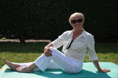middle aged caucasian doing yoga in the garden in summer sporty lifestyle at any age. High quality photo