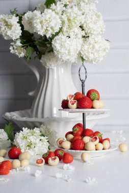 beyaz çikolata kaplı çilekli vazo ve taze çilek ile porselen vazoya karşı ortanca, klasik natürmort ve yaz yemeği. Yüksek kalite fotoğraf