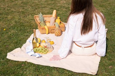 a young woman in a white shirt is resting on a picnic with her pet kitten, rest from worries and household chores, parks and recreation areas,. High quality photo