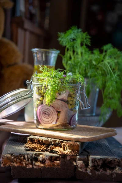 appetizer of herring with onions marinated in mustard-vinegar sauce with dill and green peas, recipe. High quality photo
