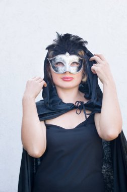 Mysterious Girl in a black cloak and a masquerade mask, mardi gras steampunk mask, a fairy tale, an enchanting story, High quality photo