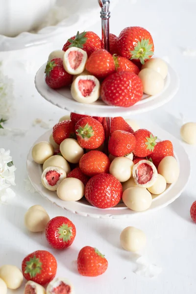 vase with white chocolate covered strawberries and fresh strawberries against porcelain vase with hydrangea, vintage still life and summer food. High quality photo