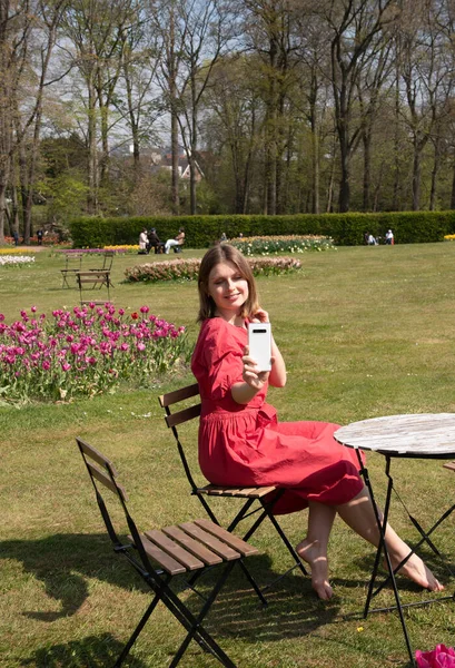 Ένα Νεαρό Όμορφο Κορίτσι Ένα Κόκκινο Φόρεμα Ένα Πάρκο Άνοιξη — Φωτογραφία Αρχείου