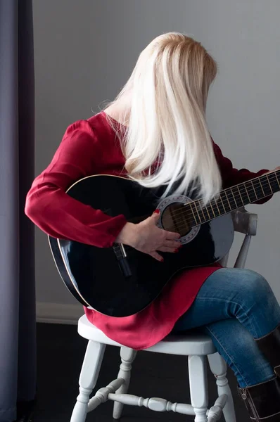 Bela Jovem Loira Vestido Vermelho Com Uma Guitarra Preta Hobby — Fotografia de Stock