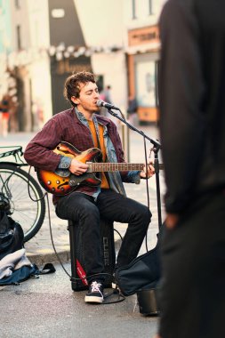 Sokak müzisyeni, sokak müzisyeninin portresi gitarını çalıyor ve alışveriş merkezindeki Galway Sanat Festivali 'nde şarkı söylüyor. 