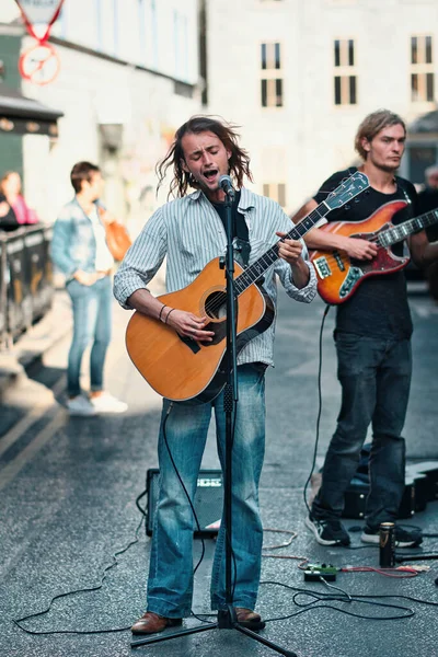 portrait shot of busker, street musician, playing his guitar and singing at Galway arts Festival in shop street 