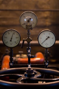 Endüstriyel buhar tesisinde eski analog basınç göstergeleri. Fotoğraf düşük ışık koşullarında çekildi, doğal ışık.