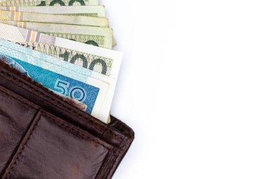 Kahverengi deri bir cüzdana yapışmış bir sürü Polonyalı banknot. Fotoğraf yapay, yumuşak ışık altında çekildi, objec beyaz arka planda izole edildi