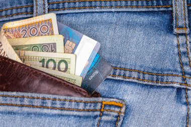 Cüzdan ve kot pantolonun arka cebinden çıkan bir sürü Polonya banknotları. Fotoğraf yapay, yumuşak ışık altında çekildi