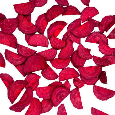 Yeni kesilmiş pancar kökünün bir sürü parçacığı beyaz arka planda gelişigüzel dağılmış. Fotoğraf yapay, yumuşak ışık altında çekildi. Beyaz arka plan. İzole edilmiş