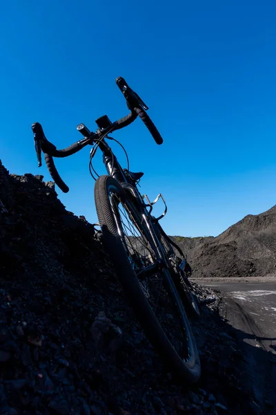 背景下的碎石自行车 在一个布满黑色砂砾的工业区骑着一辆砂砾自行车冒险 在一个美丽的阳光灿烂的日子拍照 — 图库照片